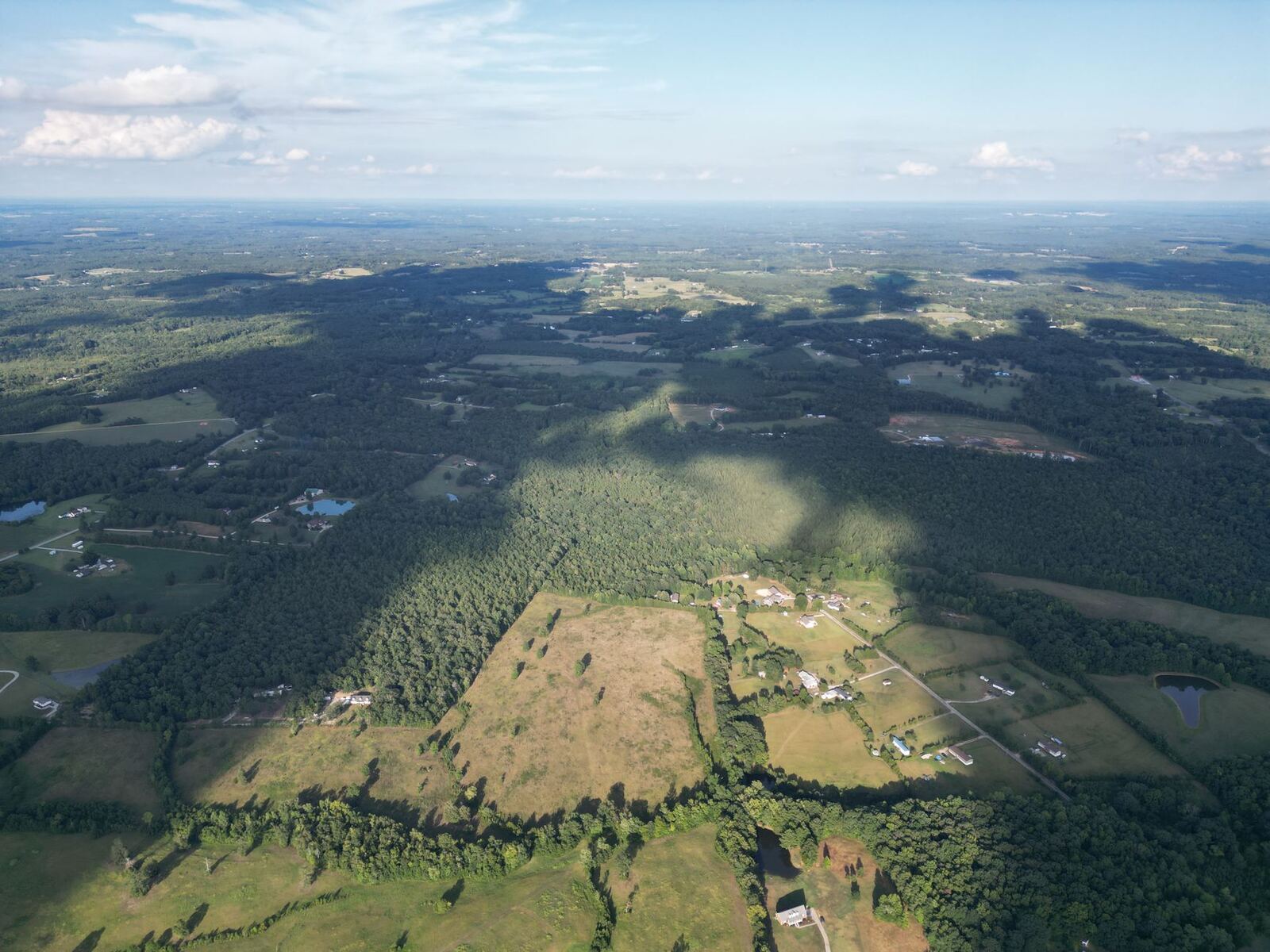 Aerial view of rolling wooded Upstate South Carolina land and pastureland near Spartanburg